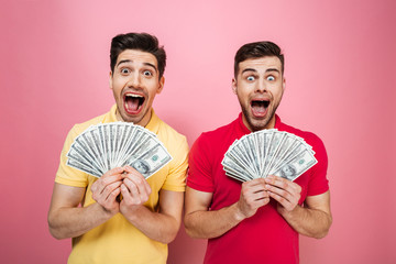 Portrait of a happy gay male couple holding money