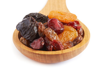 Mix of dried fruits (prunes, raisins, apricots and cranberries) in wooden spoon isolated on white background