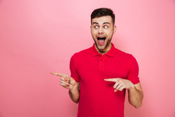 Portrait of a joyful young man pointing fingers away