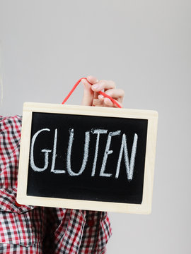 Woman holding board with gluten sign