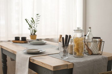 Table served with plates and potted plant in the apartment morning