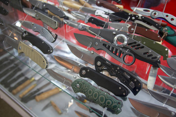 Variety of folding hunting knives on the counter