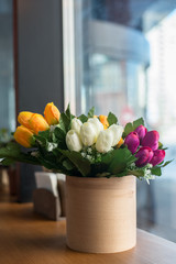  tulips in a vase by the window