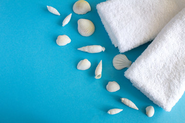 White towels and seashells  on the blue  background.Top view.