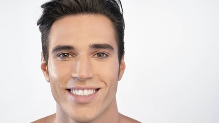 Close up of a man with moisturizer for his face smiling because he hydrates his skin and protects...