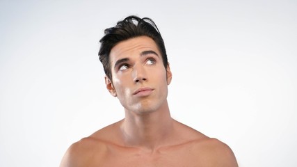 Fototapeta premium Close up of a man with moisturizer for his face smiling because he hydrates his skin and protects against impurities with anti-aging effects. Concept of: beauty and body care, creams, skincare