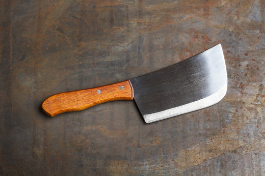 Cuchillo hacha de carnicero sobre fondo gris rústico. Vista superior