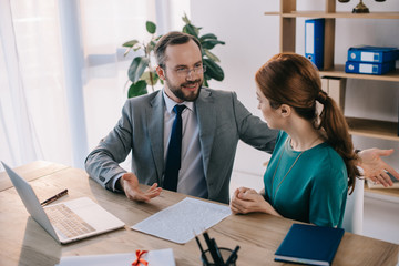 businessman and client discussing contract during meeting in office