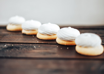 closeup white zephyr cookies lie to the line on wooden background