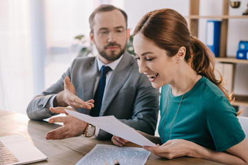 businessman and happy client discussing contract during meeting in office