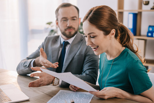 Businessman And Happy Client Discussing Contract During Meeting In Office