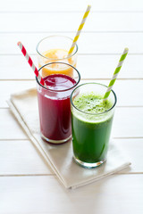 Detox drinks in glass: fresh smoothies from vegetables: beet, pumpkin and spinach on white background