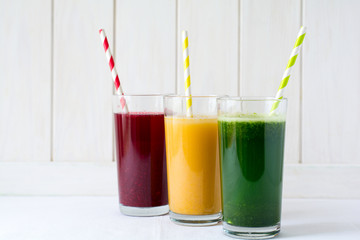 Detox drinks in glass: fresh smoothies from vegetables: beet, pumpkin and spinach on white background