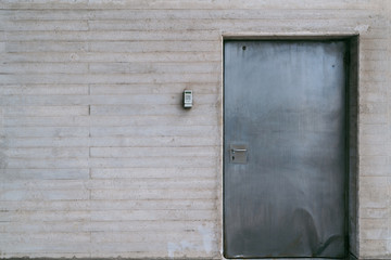 Metallic door with numeric lock on concrete wall