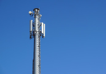 Technology on the top of the telecommunication GSM 4G tower antenna, transmitter , blue sky, white clouds.