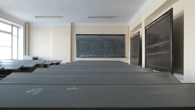 Classroom, lecture room, University hall with old desks covered with writing and illustrations by students, pupils

