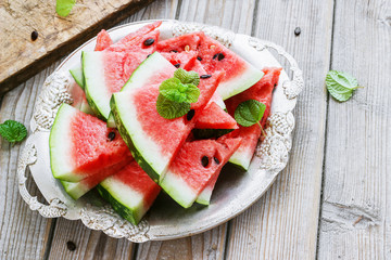 Fresh sliced watermelon in a metal bowl wooden background