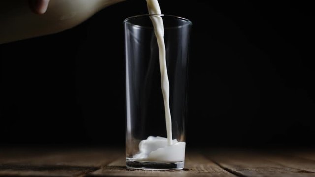 Slow motion pouring milk into glass