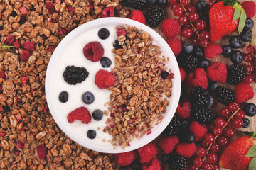 Composition of a typical genuine breakfast made with strawberry yogurt and granola. Concept of: fitness, diet, wellness and strawberries.