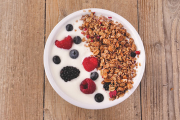 Composition of a typical genuine breakfast made with strawberry yogurt and granola. Concept of: fitness, diet, wellness and strawberries.