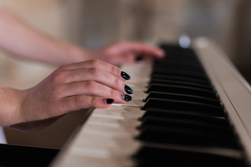 A musical instrument stands, a white keyboard synthesizer