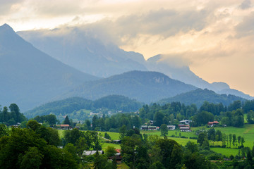 Rural summer landscape with country houses in Alps in early morning