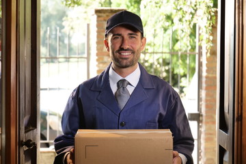Portrait of a smiling postman delivering a package