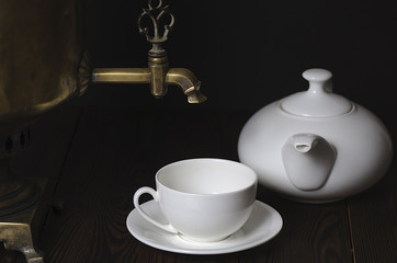 3803894 Tea cup, teapot and samovar on a dark background. Close-up, selective focus