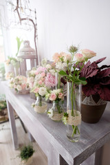 Fototapeta na wymiar Floral arrangements for events. Beautiful floral arrangements for wedding events on the table inside flower shop.