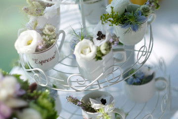 Espresso coffee coups. White coffee coups filled with flowers ornament for wedding reception event.