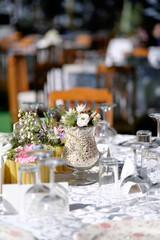Wedding event. Flowers ornaments on a white wedding table reception.
