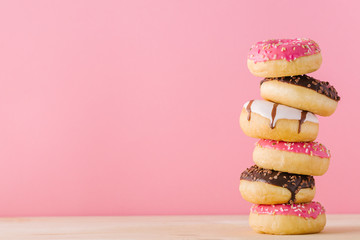 Stack of different donuts on pink