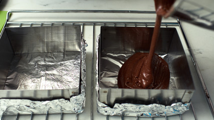 Step-by-step preparation of black designer cake. Filling the dough for baking.