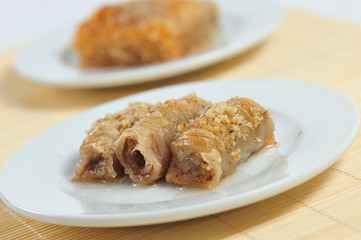 Baklava dessert food. Delicious pieces of baklava on a white porcelain dish.
