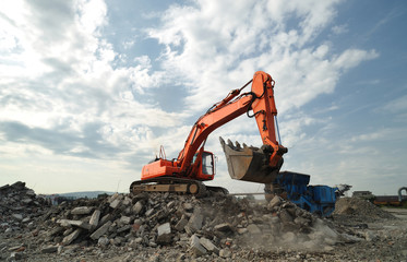 Working activity on demolition construction site. Crawler excavator and stone breaker machinery...