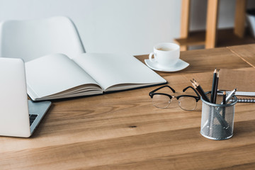 Work table with laptop and stationery in office