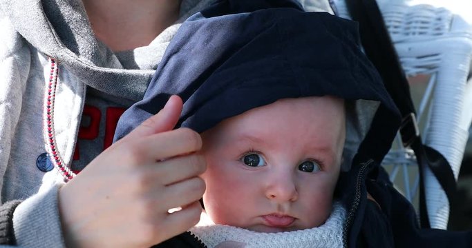 Portrait Of Cute Baby Boy Four Month Old With Blue Hood on His Head. Mother Holding Her Baby in Her Arms. Close Up View - DCi 4K Resolution
