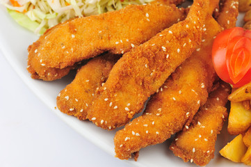 Shanghai chicken with garnish. Shanghai chicken on the plate with baked potatoes, cabbage salad and tomatoes slices.