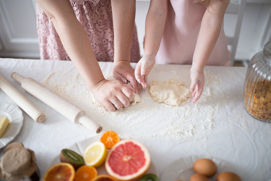 Daughter with mom knead dough for biscuits