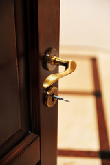 Golden door handle. Closeup view of a golden handle of the room door.