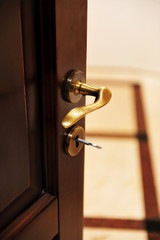 Naklejka premium Golden door handle. Closeup view of a golden handle of the room door.