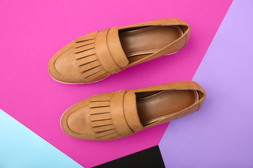 Pair of female shoes on color background