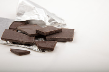Chocolate bar close Up, in silver foil on gray background..