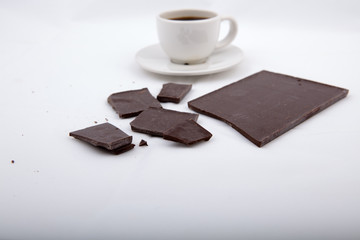 Dark chocolate with black coffee on gray surface