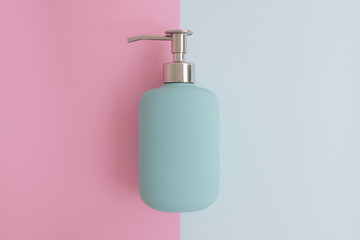 Minimal flat lay concept of blue shower gel, shampoo or cosmetic bottle on the colorful background with copy space