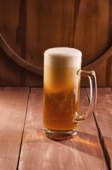 Fresh and cold beer in glass. Tasty beer concept on wooden background.