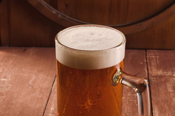 Fresh and cold beer in glass. Tasty beer concept on wooden background.
