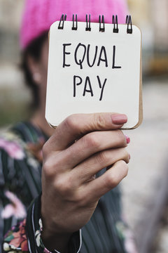 woman with a pink hat and the text equal pay.