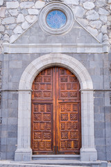 Carved wooden door with a bull's-eye of a church of San Pedro Apostol on the island of Tenerife in...