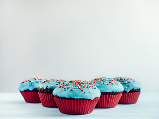 Festive, fragrant cupcakes, covered with turquoise glaze and bright decoration for baking on a white background